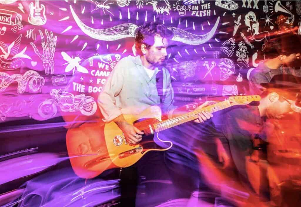 Live guitar performance at St Christopher’s Newquay hostel with colourful graffiti art.