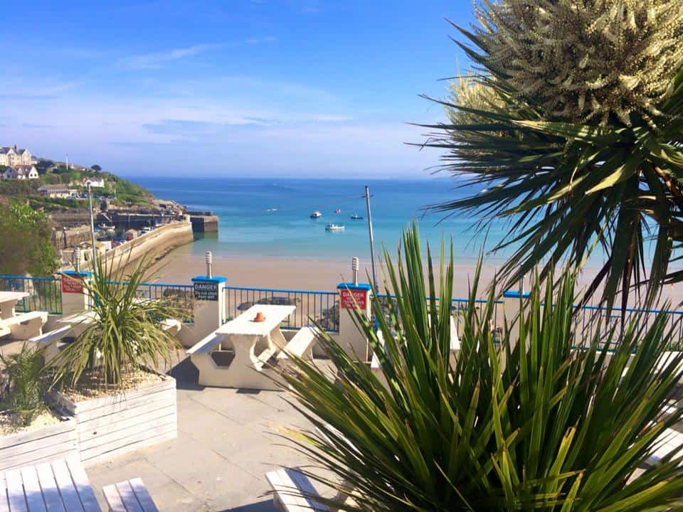 Exterior view of St Christopher’s Newquay hostel overlooking the beach and ocean.