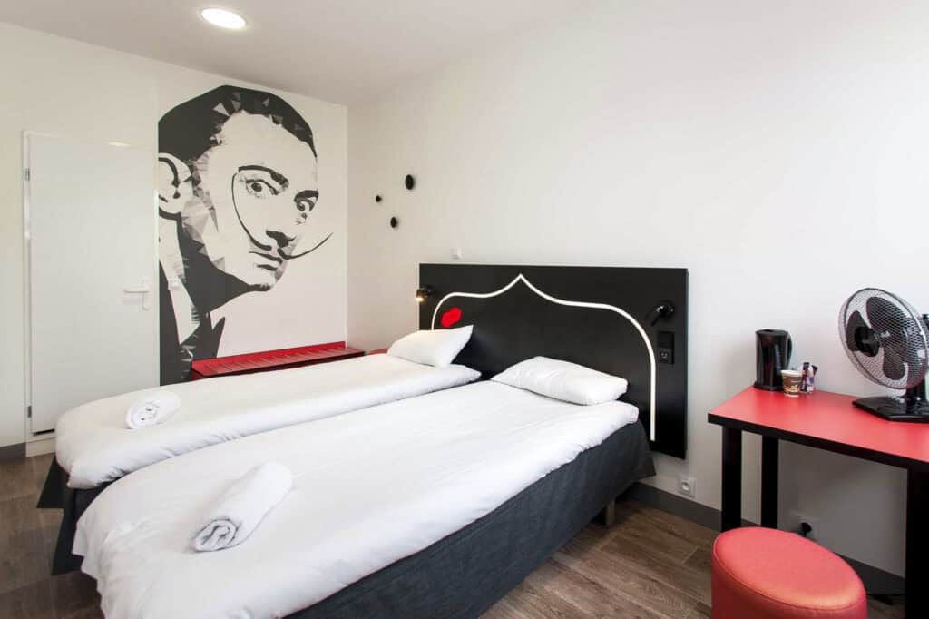 Modern hostel room with twin beds and contemporary decor at Gare du Nord, Paris.