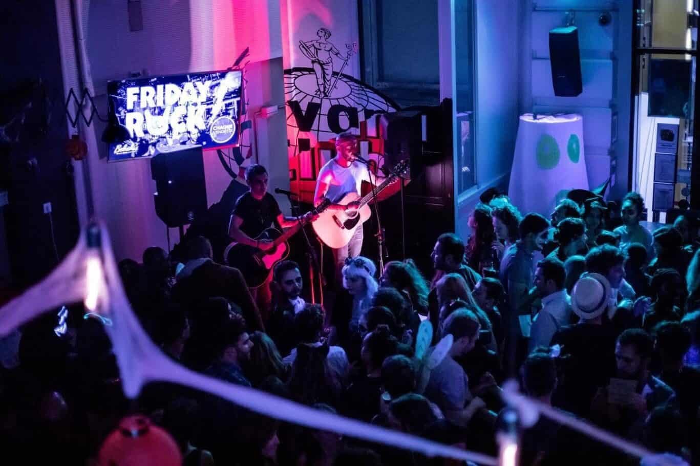 Live music performance with two guitarists entertaining guests at Gare du Nord hostel.