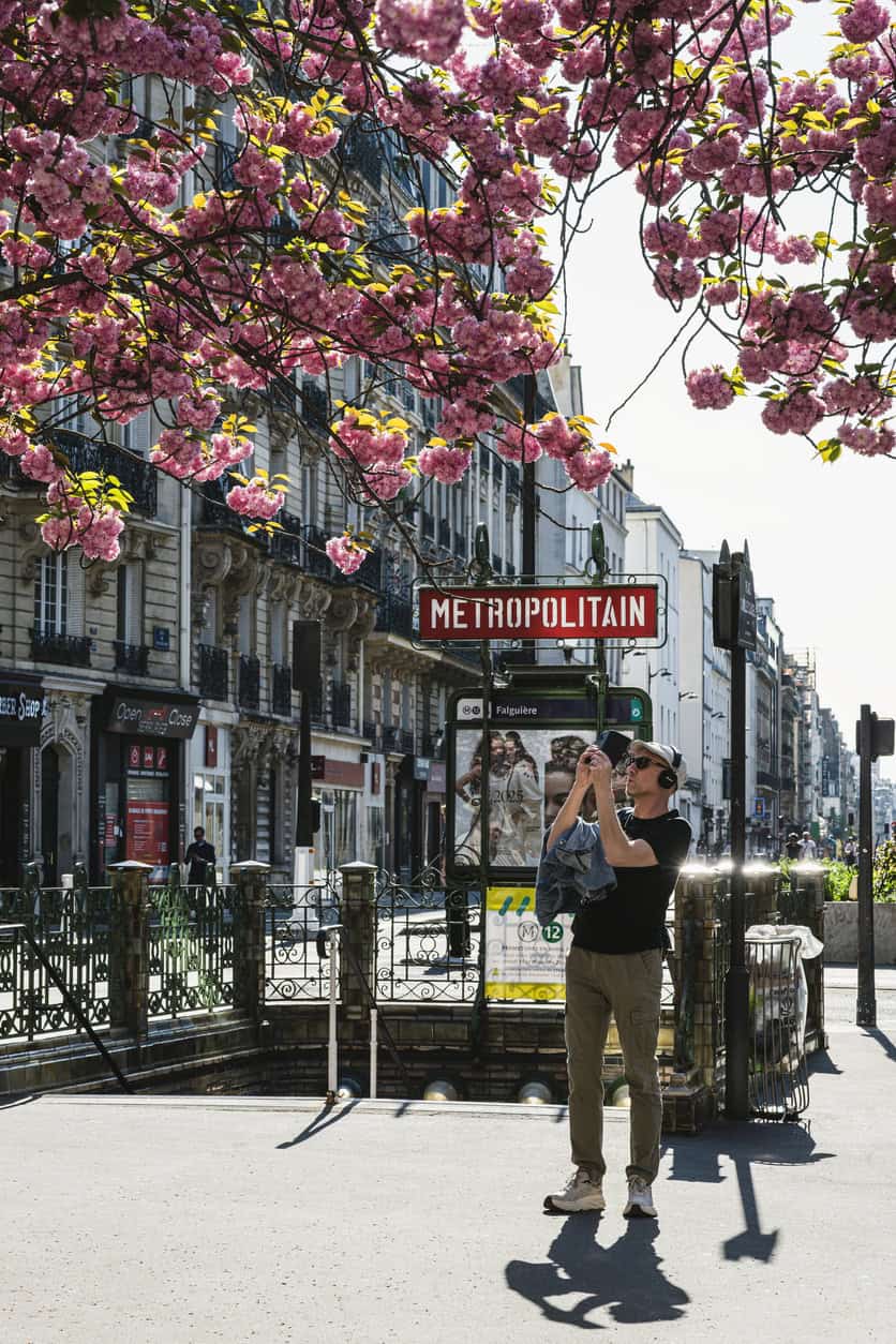 Gare du Nord station in Paris with cherry blossoms and travelers.