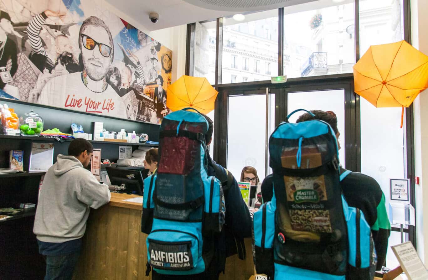 Reception area at St Christopher’s Gare du Nord hostel in Paris with guests and staff.