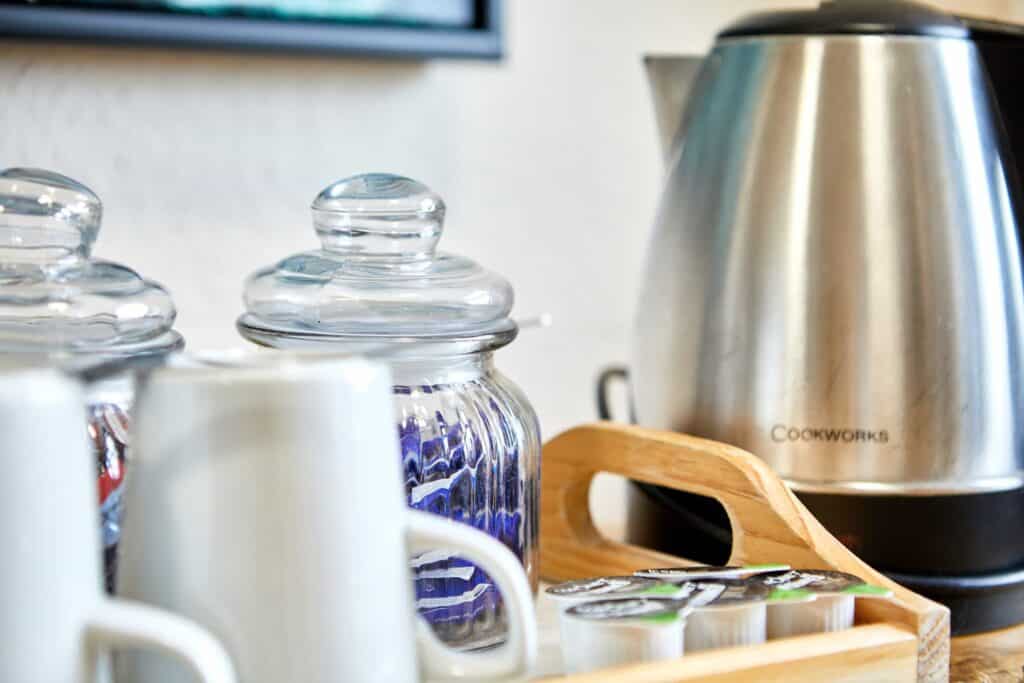 Kitchen amenities at St Christopher's Shepherd's Bush hostel with jars and kettle.