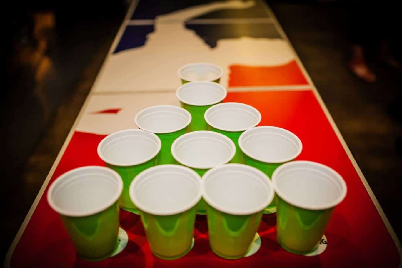 Beer pong cups set up on a table with a UK flag design in the background.