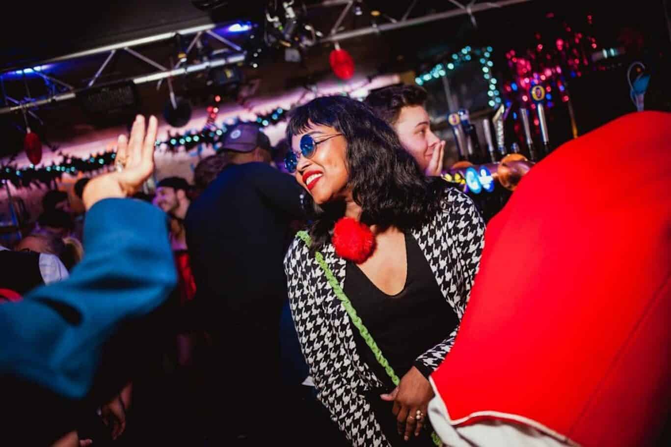 A woman dancing and enjoying nightlife at St Christopher's Shepherd's Bush Hostel.