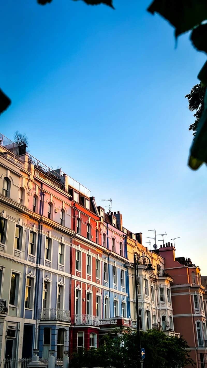 Colorful Victorian buildings in Shepherd's Bush, London, under a clear blue sky.