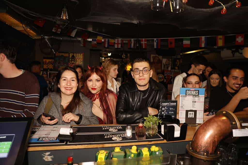 Lively group of young adults enjoying drinks at St Christopher’s Vienna hostel bar.