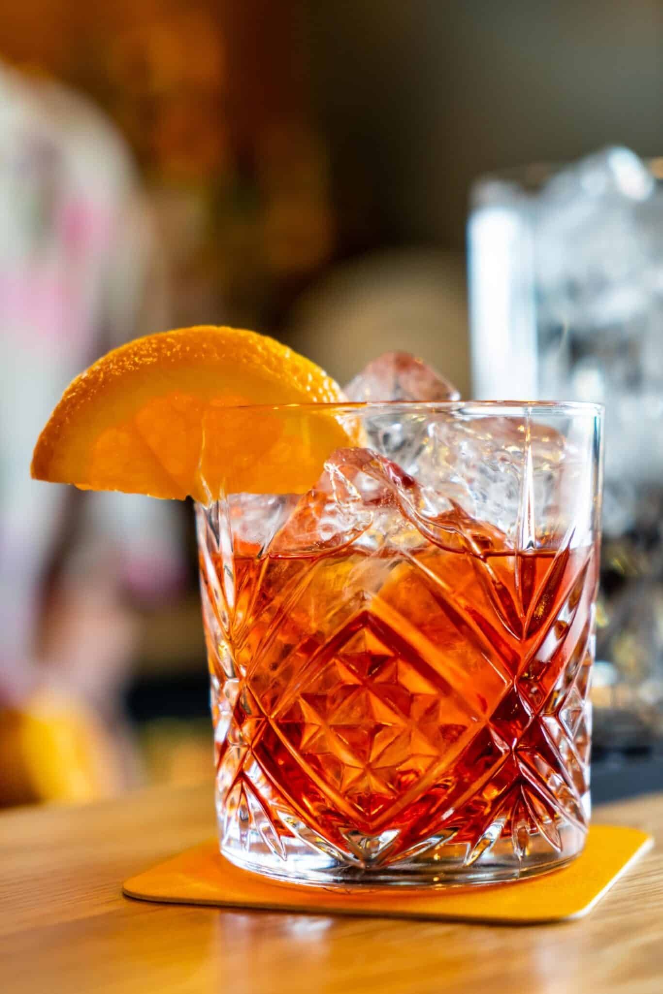 Refreshing cocktail with orange slice at St Christopher’s Vienna hostel bar.