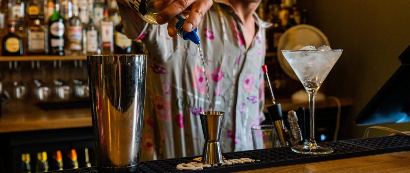 Young bartender preparing a cocktail at St Christopher’s Vienna hostel bar.