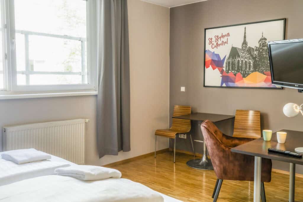Modern hostel room at St Christopher’s Vienna with comfortable beds and workspace.
