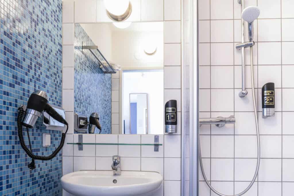 Modern hostel bathroom with shower and sink in Vienna.