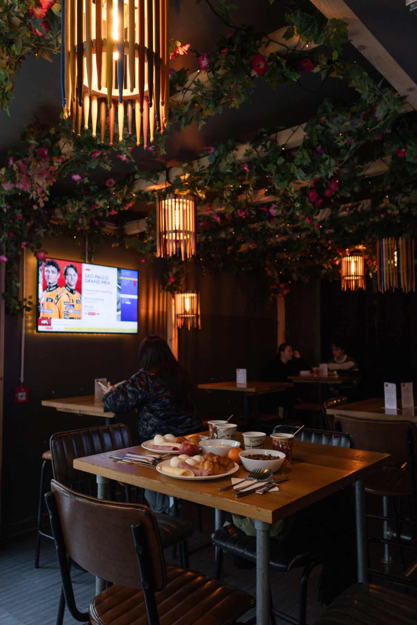 Interior view of a cozy dining area at St Christopher’s Vienna Hostel with warm lighting and floral.