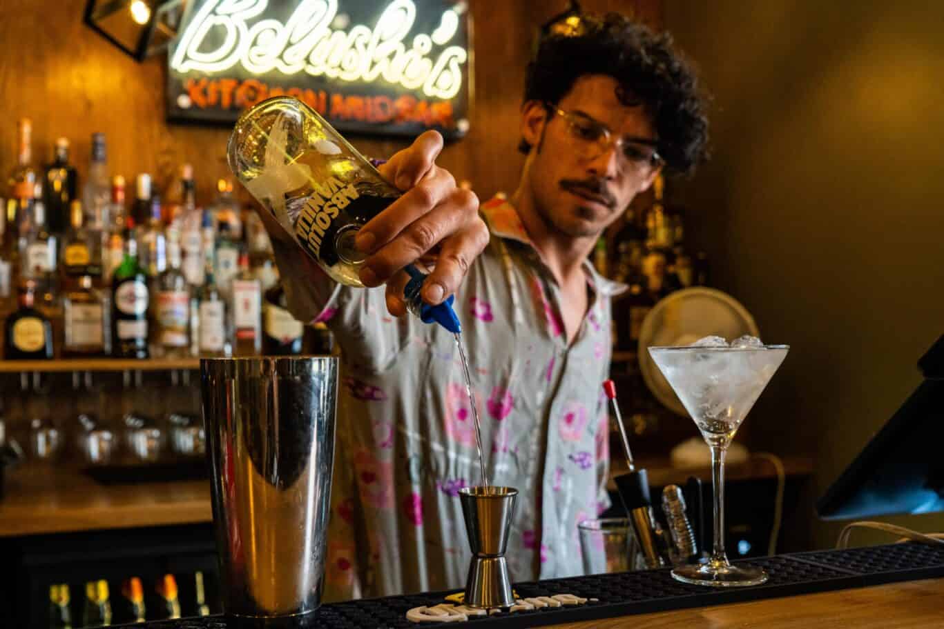 Young bartender preparing a cocktail at St Christopher’s Vienna hostel bar.