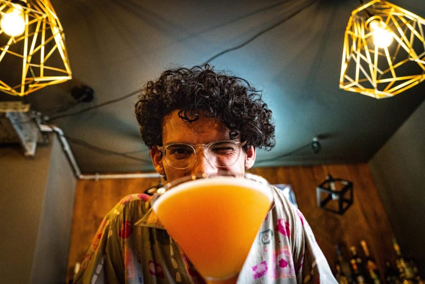 Young man enjoying a cocktail at St Christopher’s Vienna hostel bar.