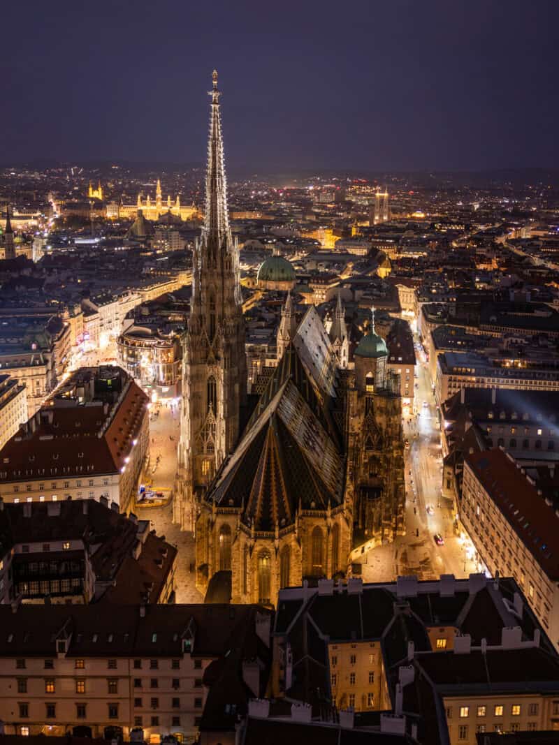 Vienna, Austria. Symmetrical night aerial view of St. Stephen’s Cathedral and illuminated city streets