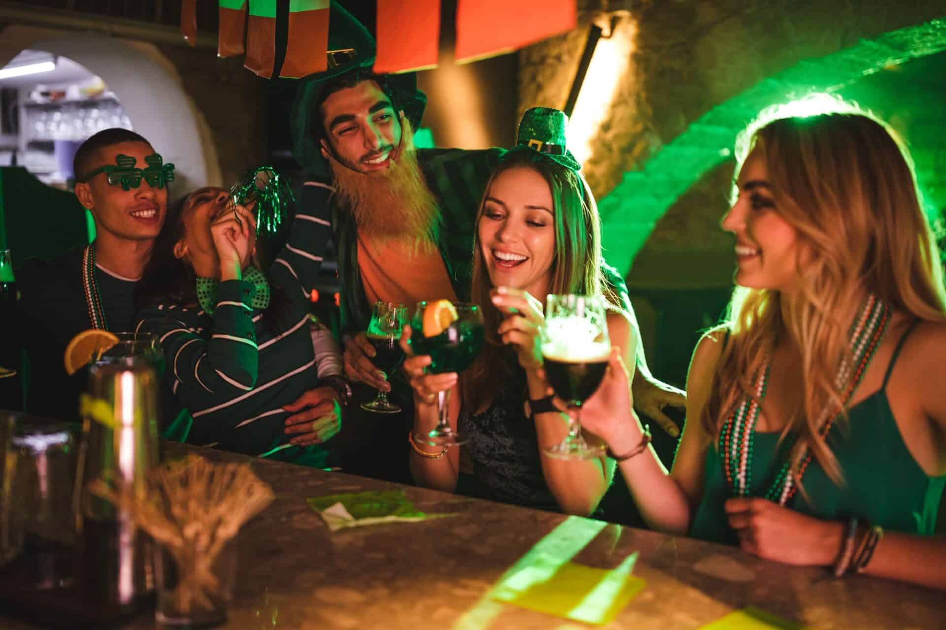 A group of friends enjoying drinks and socialising in a vibrant bar setting.