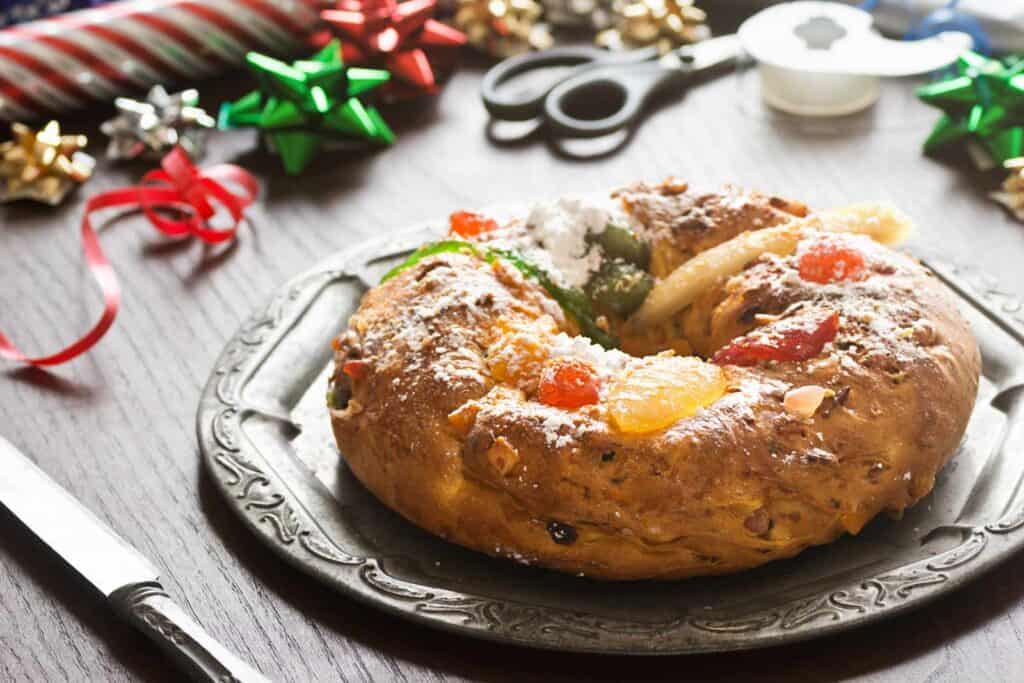Traditional Christmas fruitcake with dried fruits and nuts, served on a decorative plate.