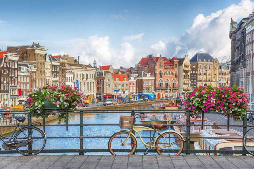 Scenic view of Berlin canal with colourful historic buildings and bicycles in the foreground.