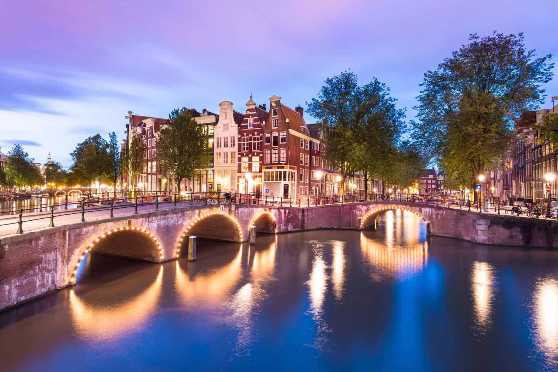 Historic canal view in Berlin at dusk with illuminated bridges and traditional architecture.