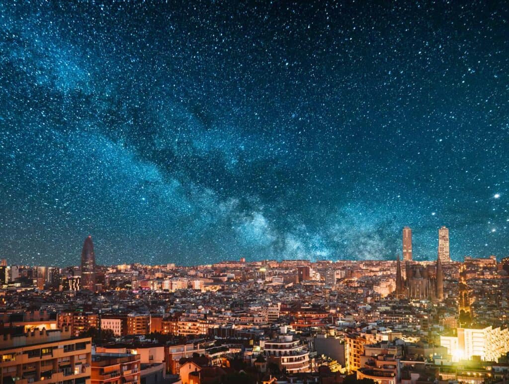 Night sky over Berlin cityscape with stars and Milky Way visible above Mitte district.
