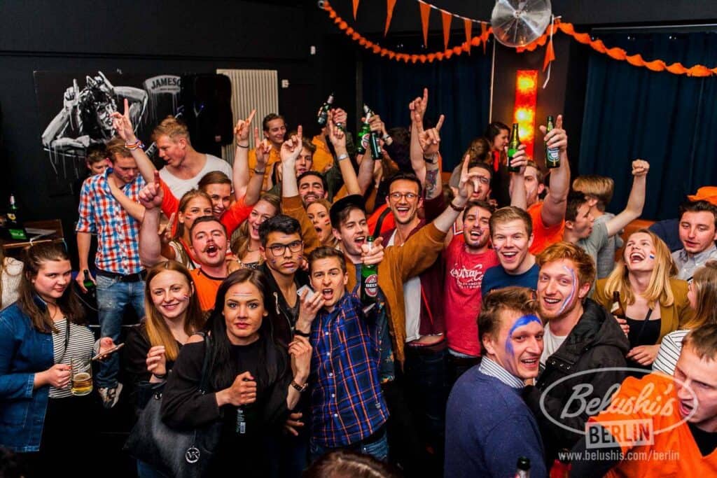 Lively group of young people celebrating at St Christopher’s Berlin hostel party in Mitte district.