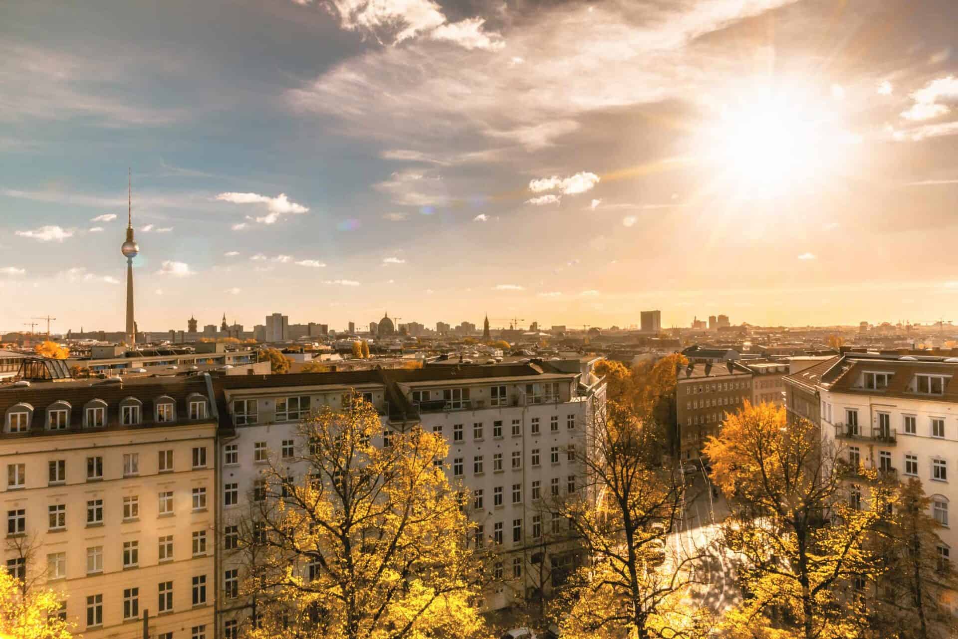 View of Berlin skyline from Mitte Hostel, showcasing historic buildings and the TV Tower at sunset.