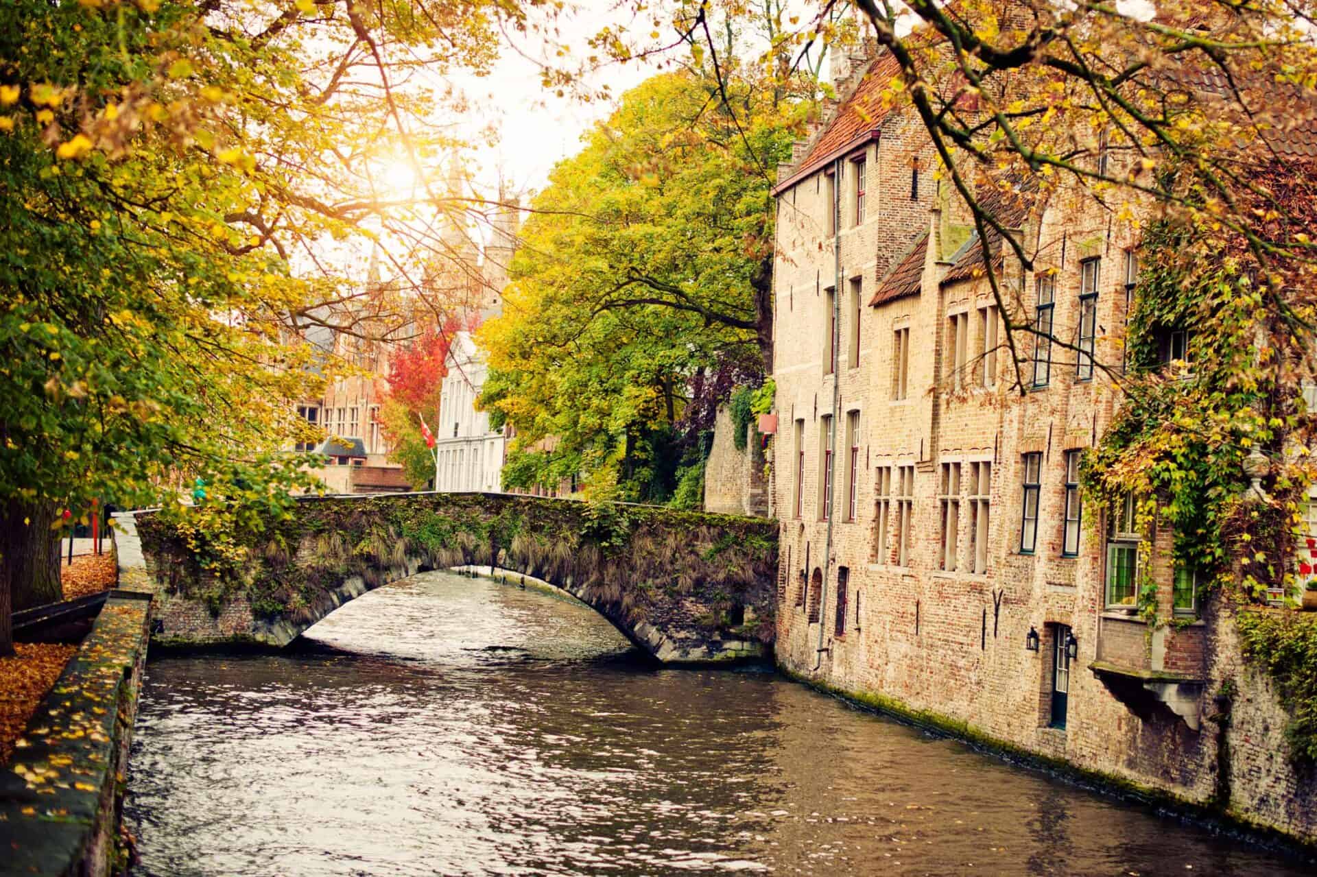 Historic Berlin canal with autumn foliage and old buildings.