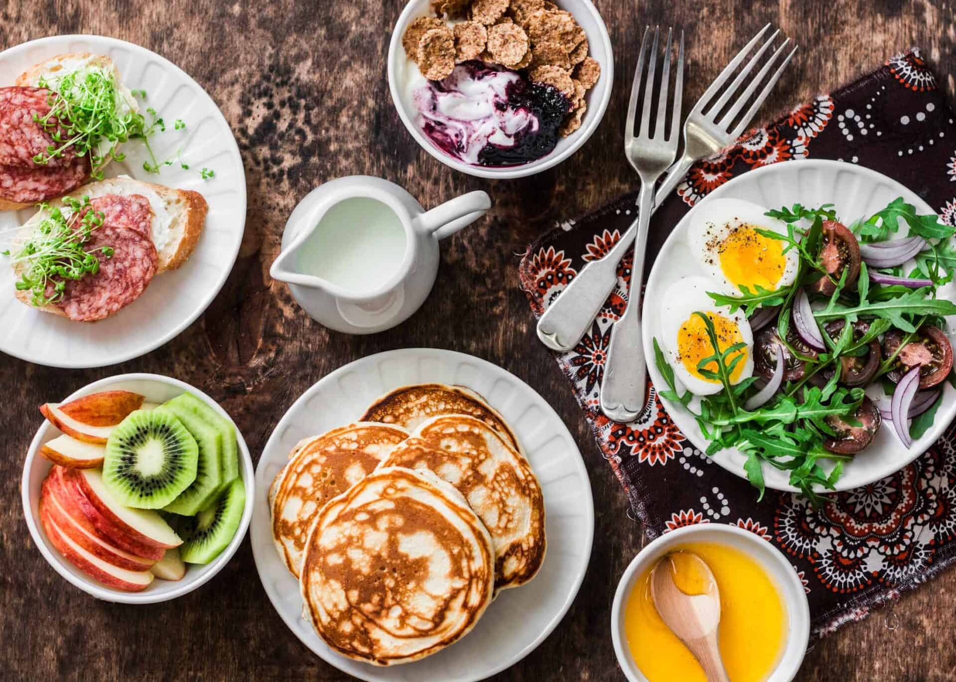 Bright breakfast spread with pancakes, fresh fruit, salad, and beverages at St Christopher’s Berlin.