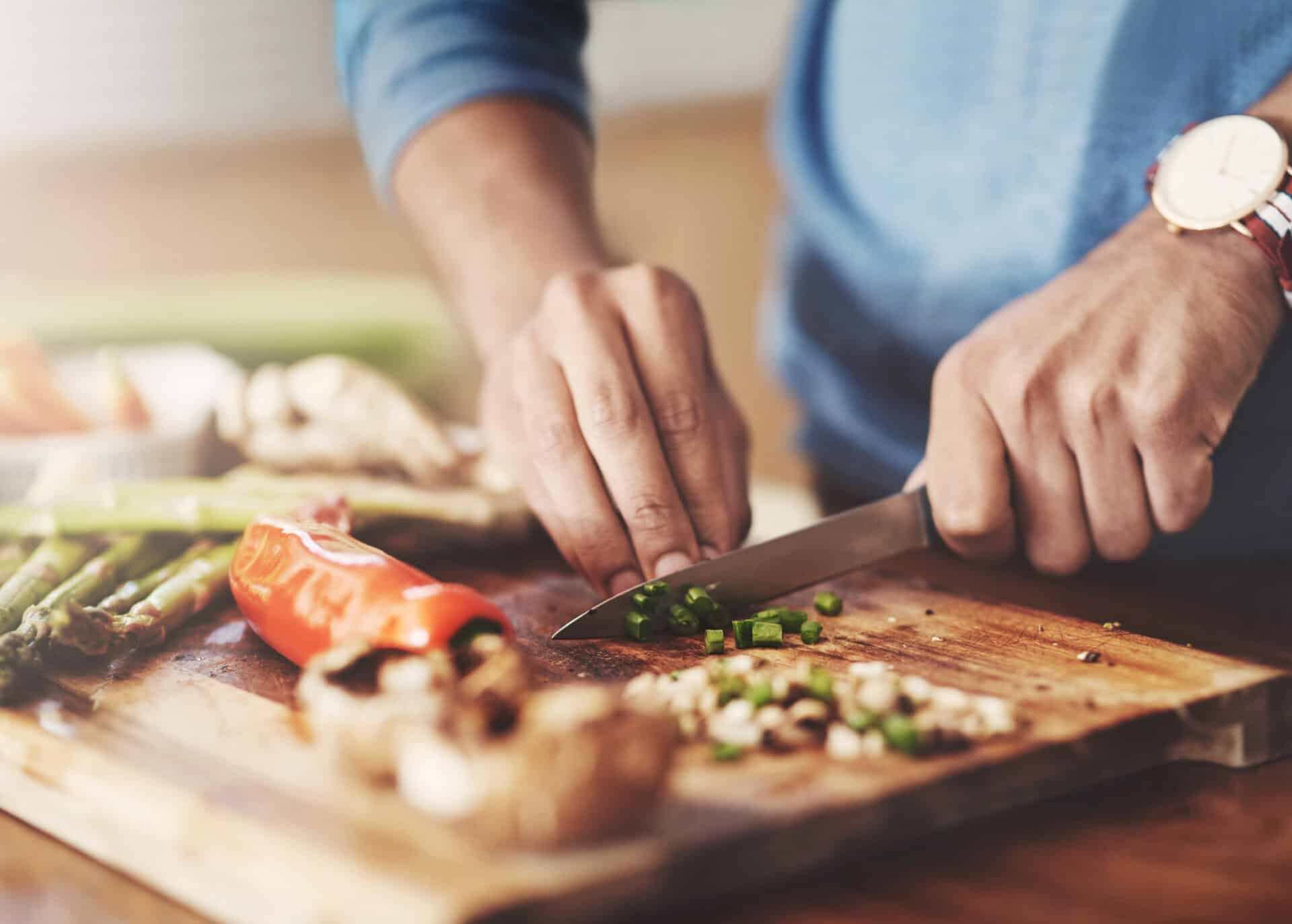 Vegetables being chopped on a wooden cutting board at Mitte Hostel, Berlin.