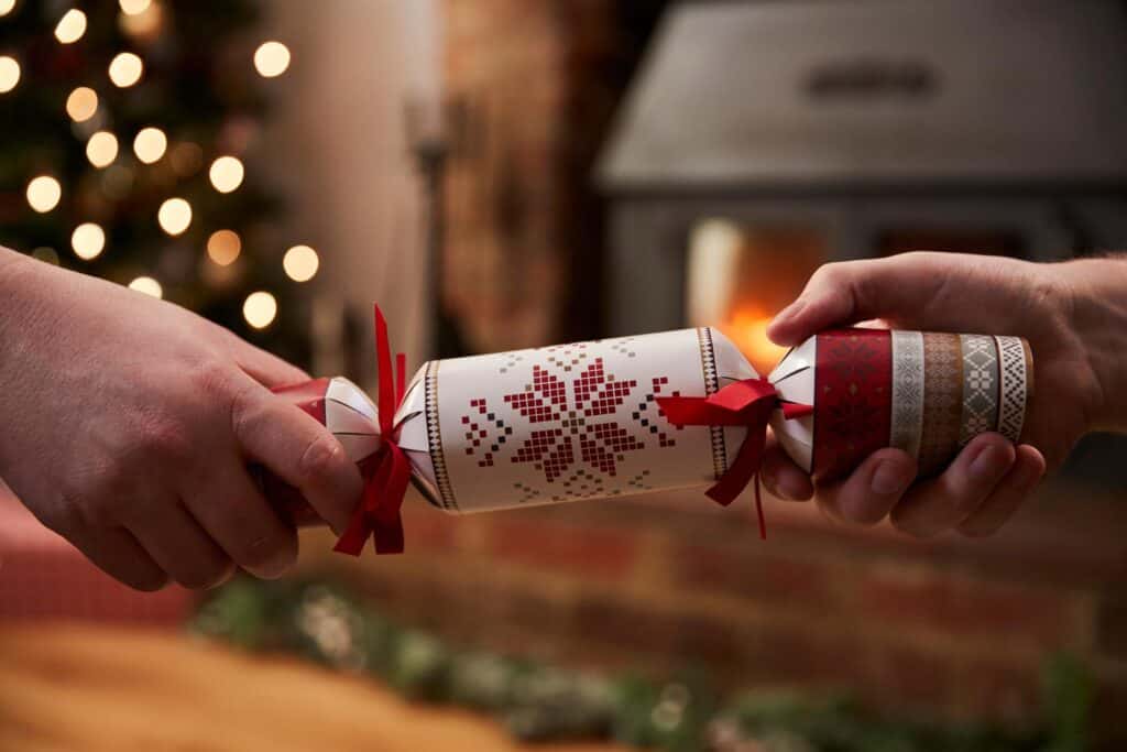 Festive Christmas crackers being pulled in a cozy holiday setting at St Christopher’s Berlin Mitte.