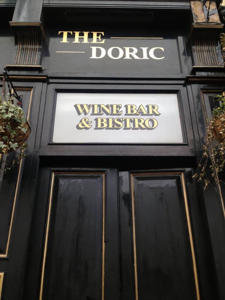 Entrance to The Doric Wine Bar & Bistro in Berlin, featuring elegant black and gold signage.