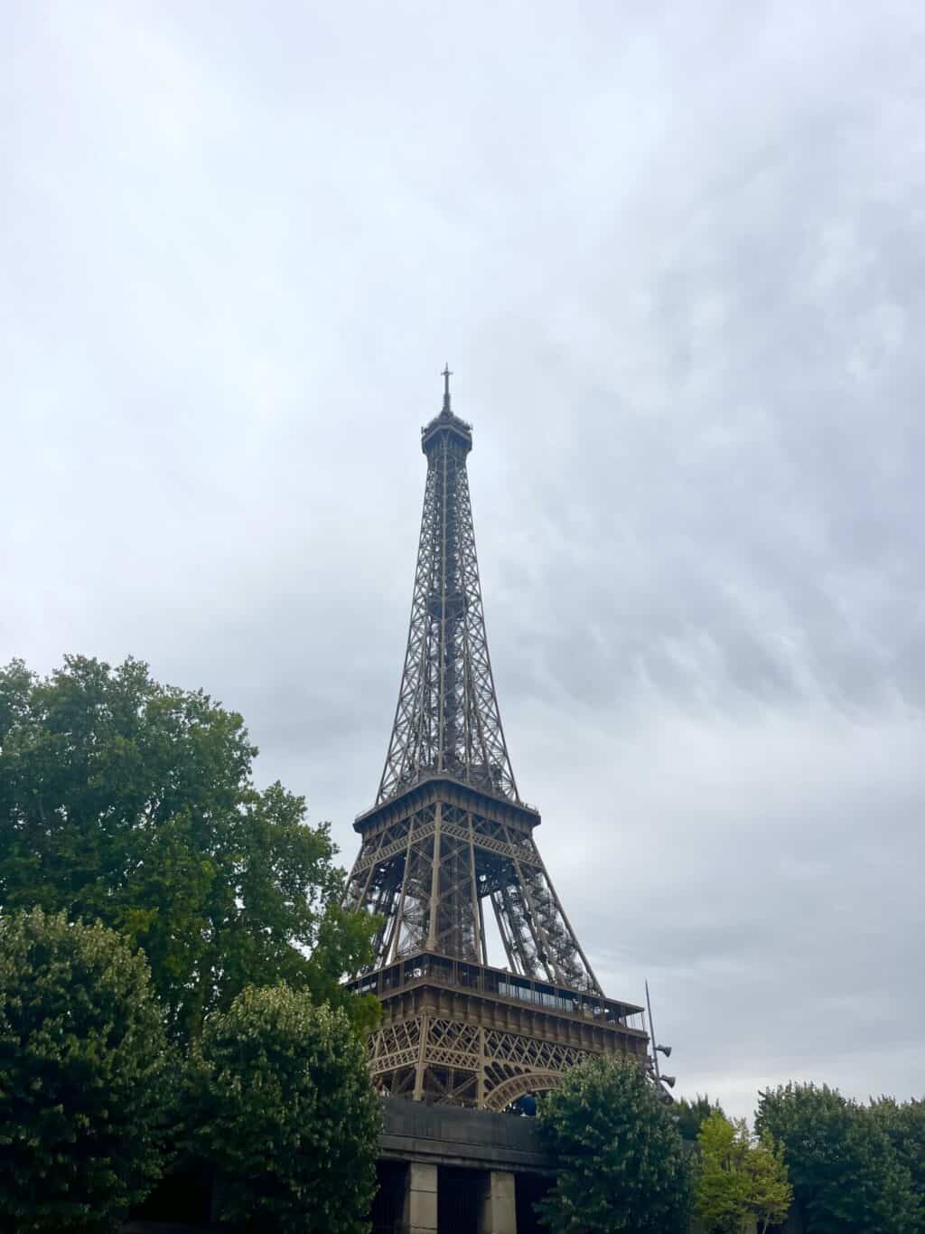 Eiffel Tower replica visible from Mitte Hostel in Berlin, with trees and cloudy sky in the backgroun.
