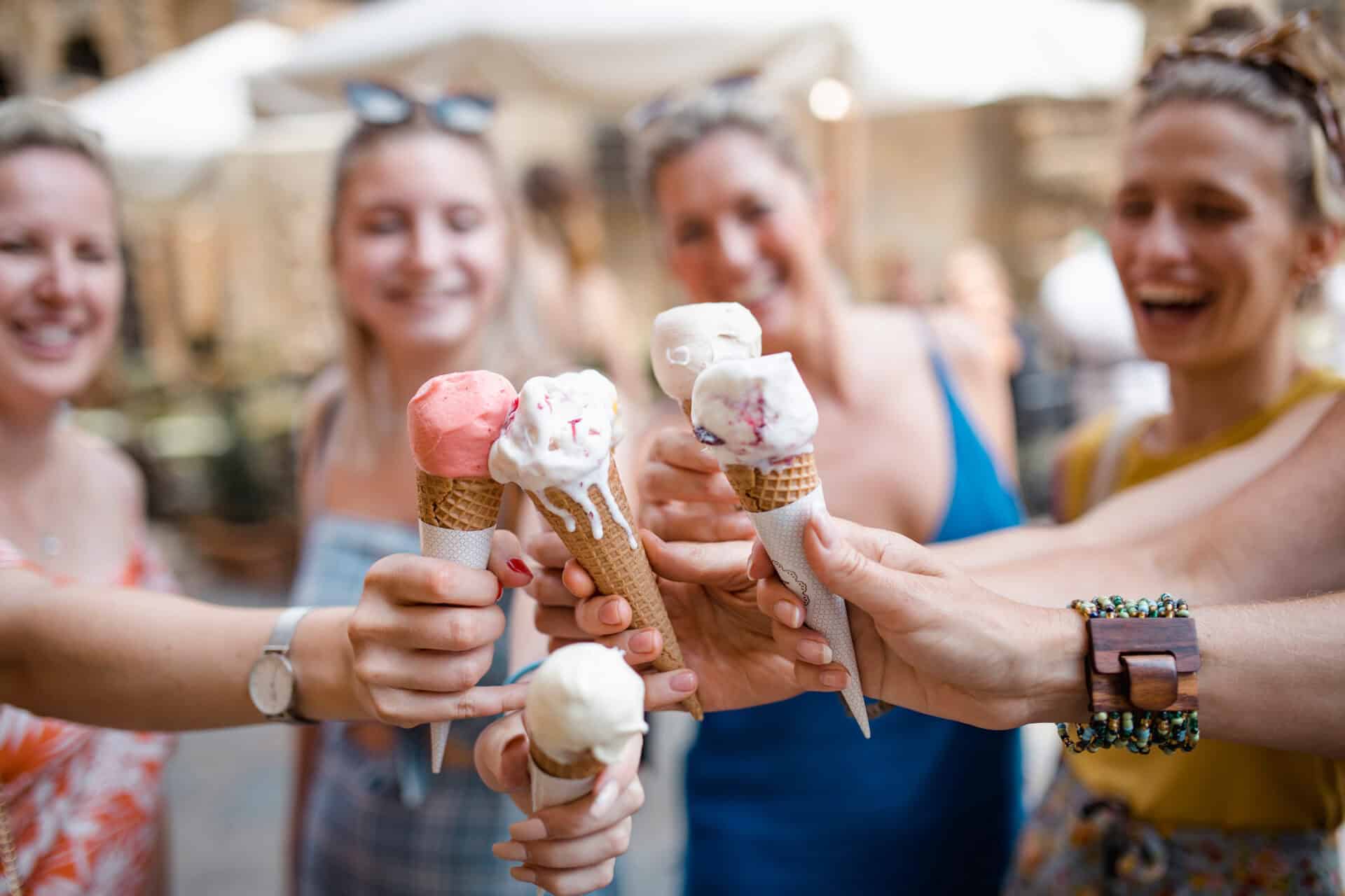Ice cream cones held by smiling women at St Christopher’s Berlin - Mitte, a popular hostel in Berlin.