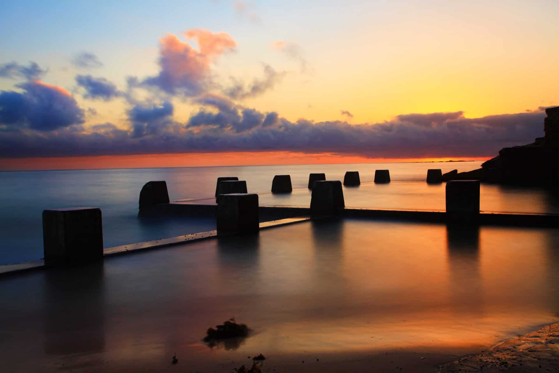 Sunset over the Baltic Sea with pier structures at Mitte Hostel Berlin.