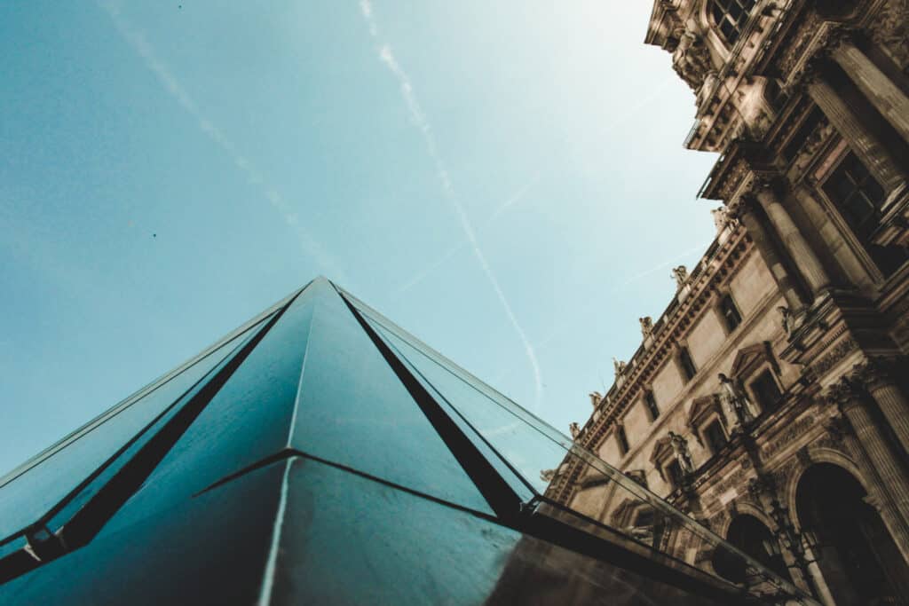 Contemporary glass architecture in Berlin with historic buildings nearby.