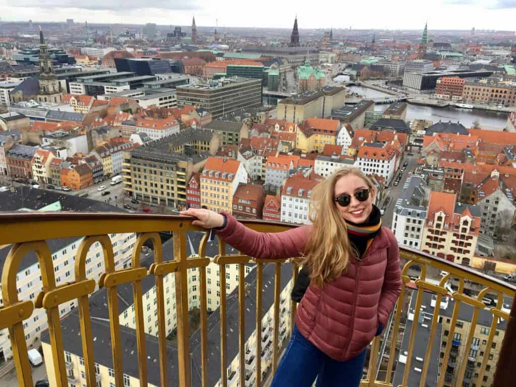 Young woman enjoying panoramic city views from Mitte Hostel rooftop in Berlin.