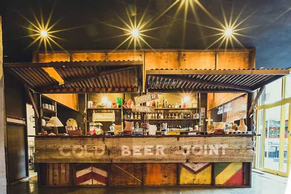 Modern hostel bar in Berlin Mitte with rustic decor and vibrant lighting.