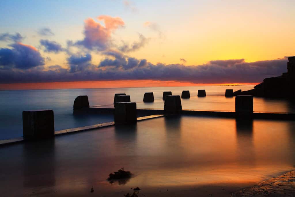 Sunset over Berlin Mitte with calm waters and historic pier structures.