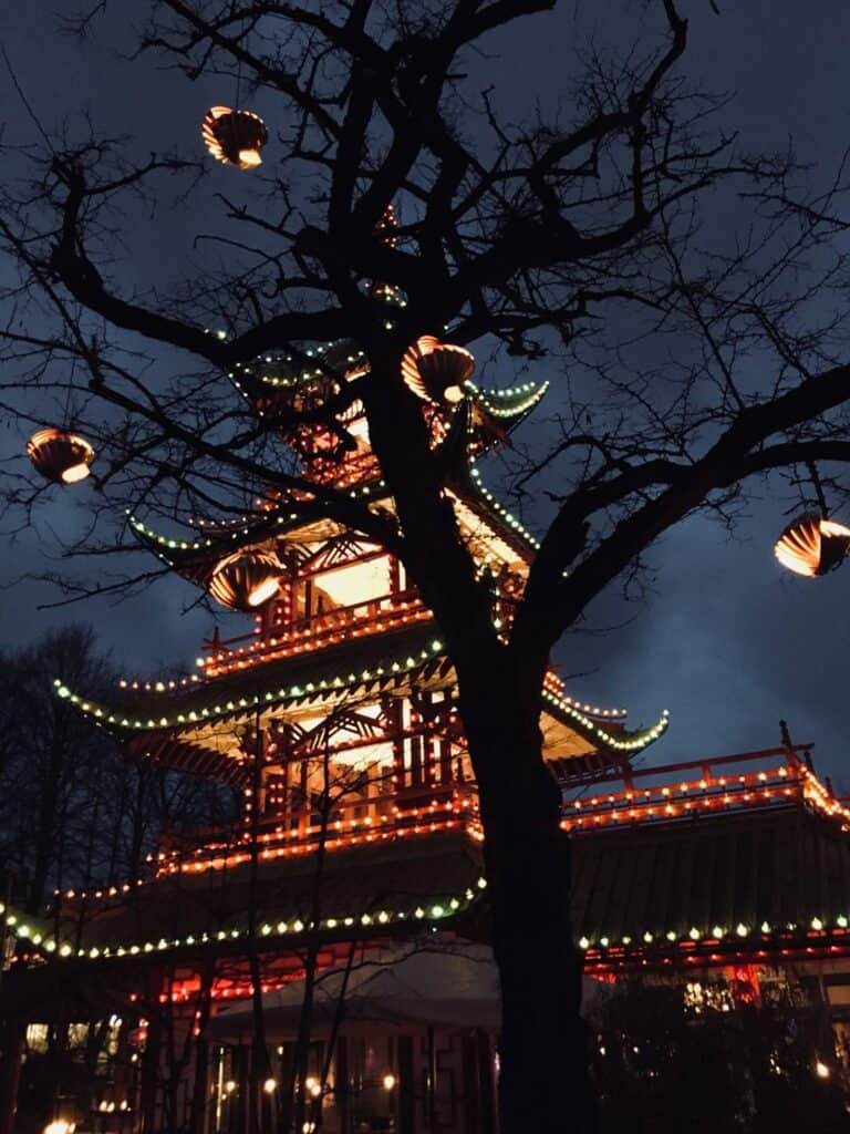 Traditional Chinese pagoda illuminated at night with lanterns in Berlin, showcasing cultural archite.