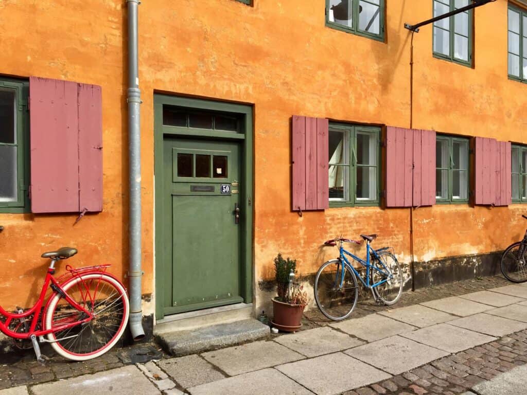 Colourful Mitte hostel entrance with bicycles and potted plants in Berlin, Germany.