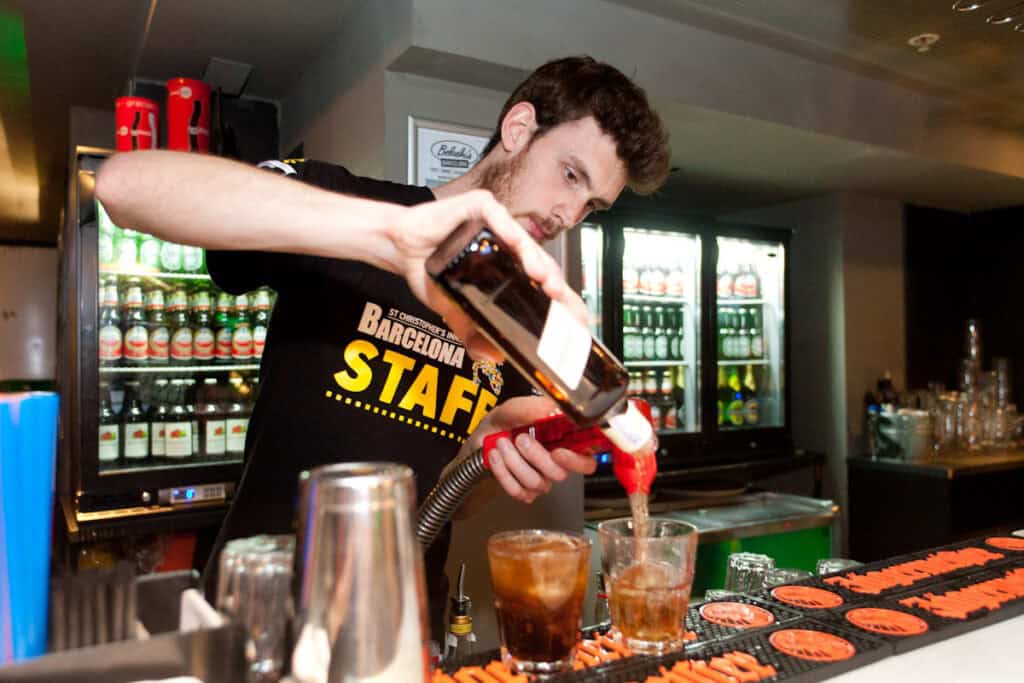 Bartender preparing cocktails at St Christopher’s Berlin hostel bar.