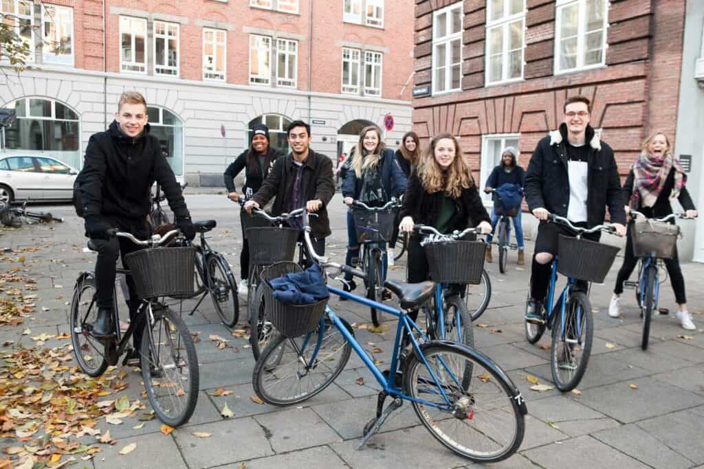 Vibrant group of diverse young adults with bicycles enjoying a day in Berlin's Mitte district.
