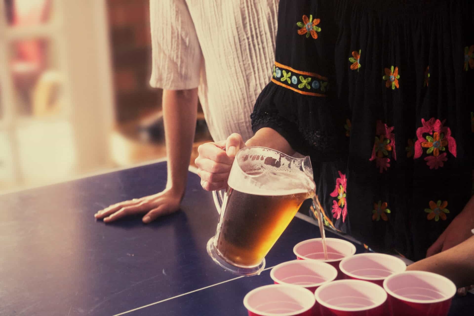People playing beer pong at Mitte Hostel Berlin, social atmosphere, casual drinks, and fun.