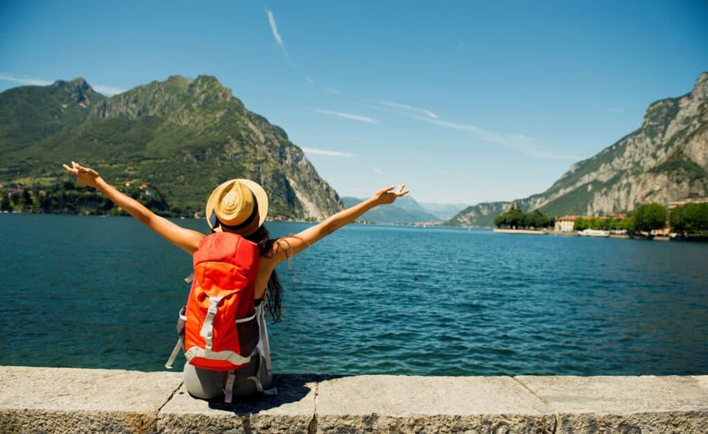 Woman with backpack enjoying scenic lake view in Berlin Mitte, Germany.