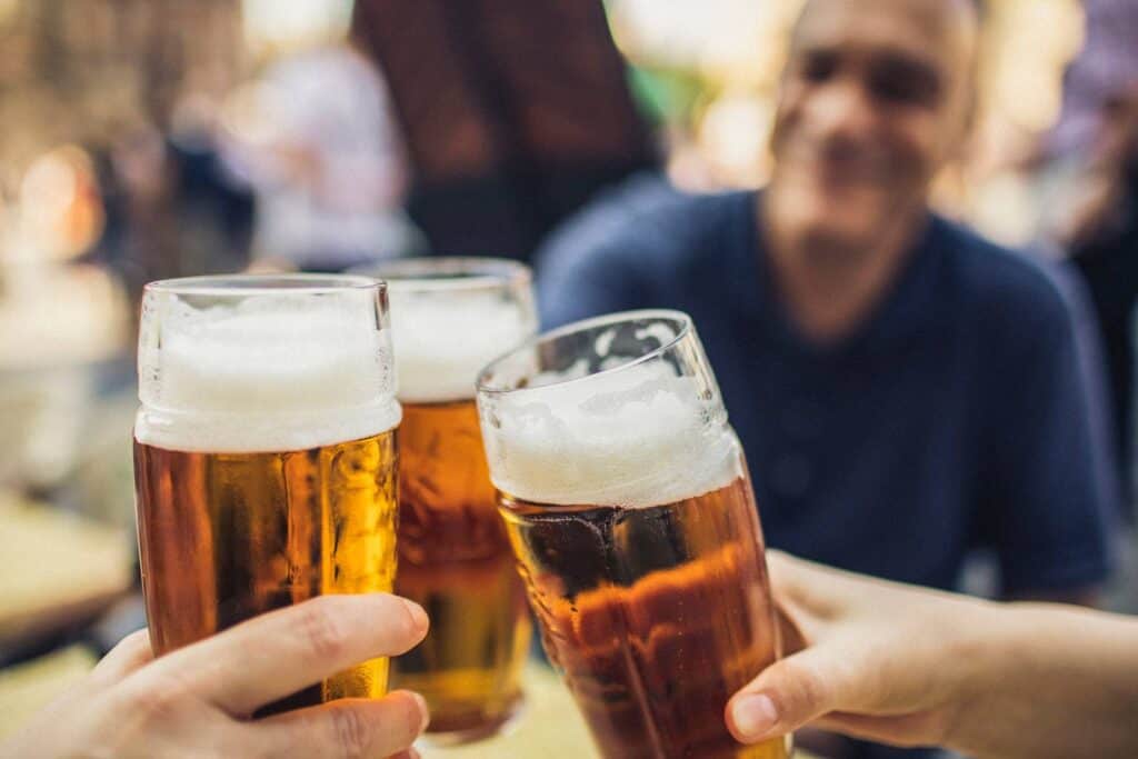 Group of friends clinking glasses of beer at Mitte Hostel Berlin.