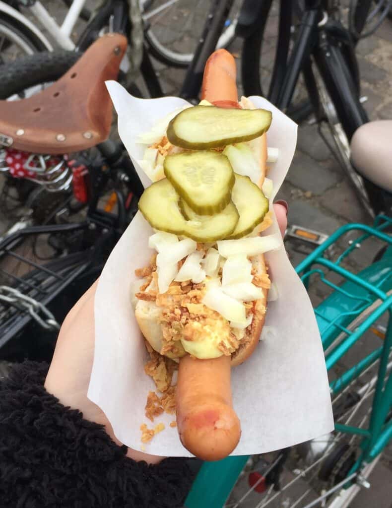 Classic Berlin street food hot dog with pickles and cabbage.