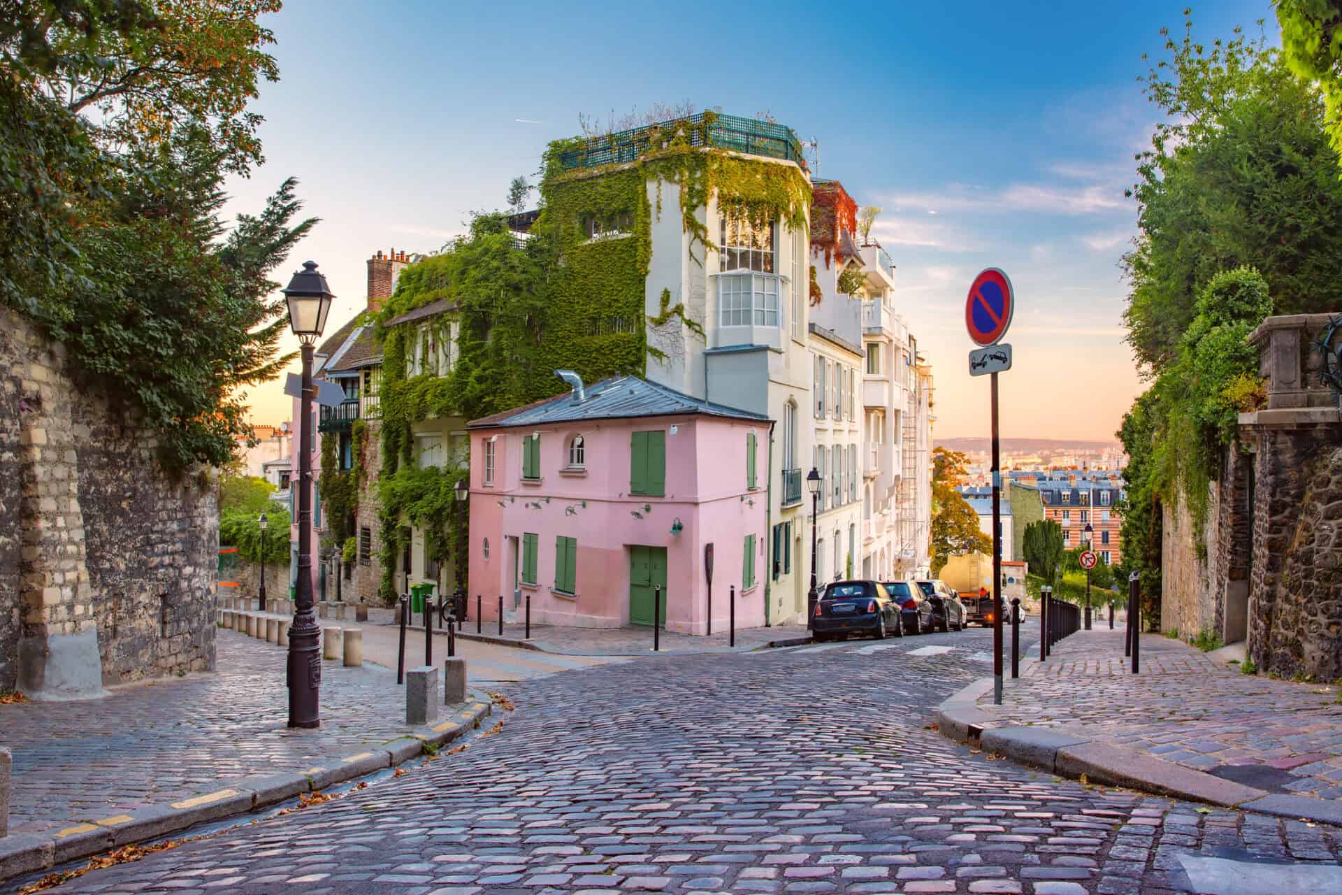 Historic street view of Mitte Hostel in Berlin with cobblestone roads and lush greenery.