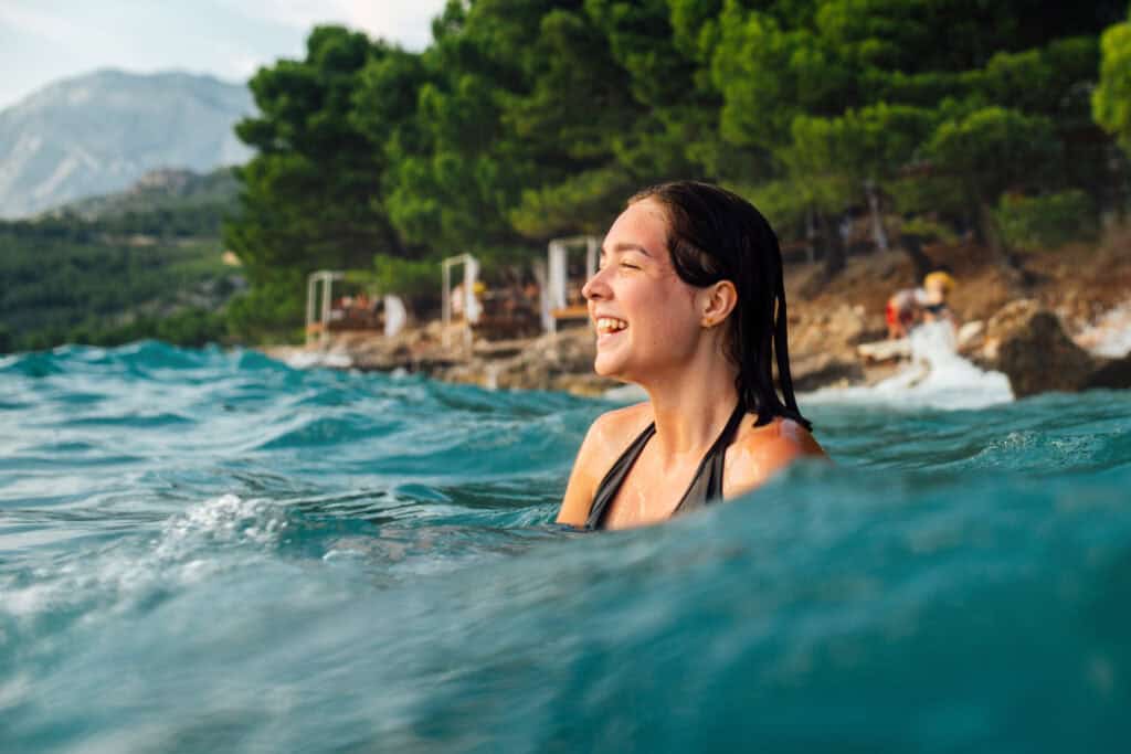 Young woman enjoying swimming in outdoor pool at Mitte Hostel, Berlin.