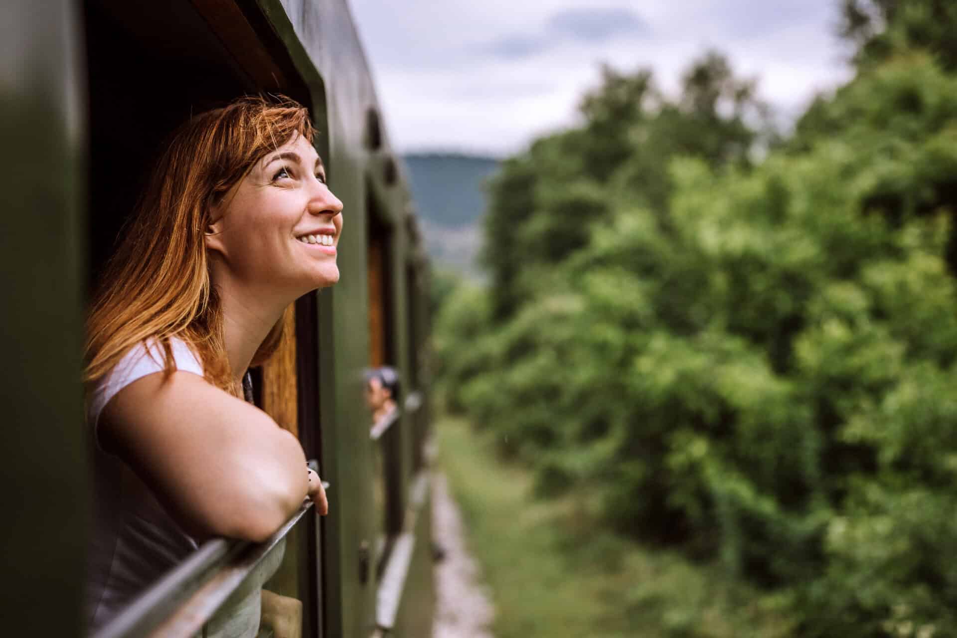 Young woman enjoying the scenic view from a train window at Mitte Hostel, Berlin.