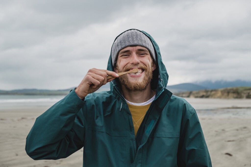 Young man enjoying outdoor scenery at Mitte Hostel Berlin, smiling with a snack.